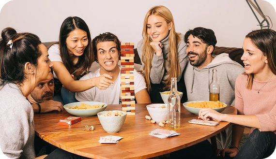 Amici concentrati durante una partita con una torre di blocchi in legno